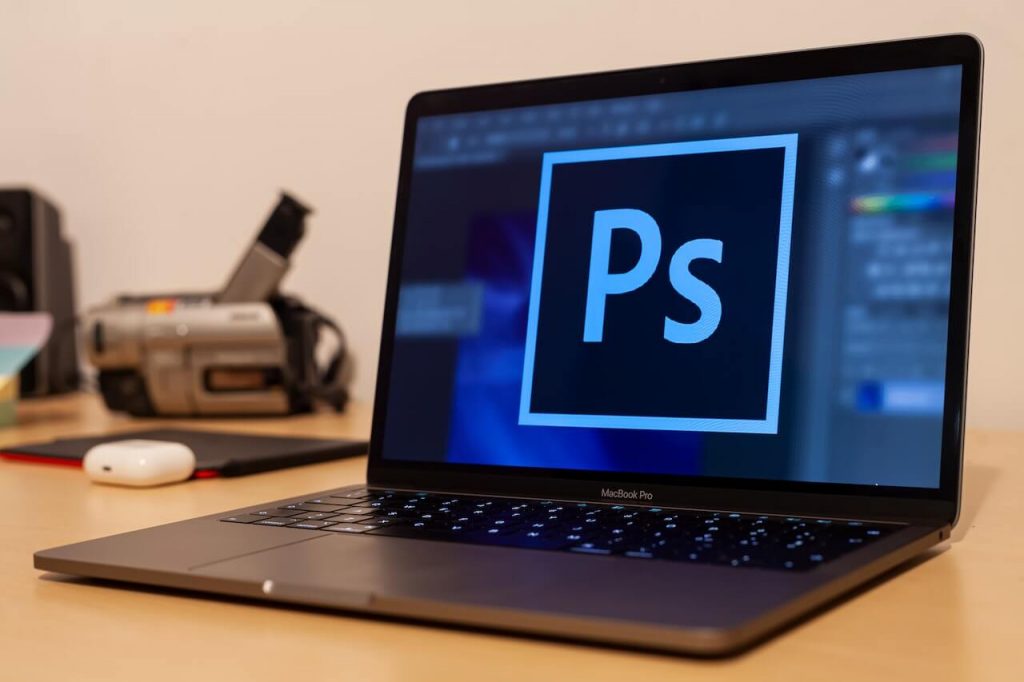 Computer with the Photoshop logo displayed on the screen, representing photo editing and graphic design capabilities.
